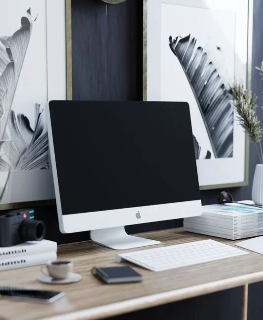 A modern office workspace featuring computers, charts, and office supplies for a productive environment.